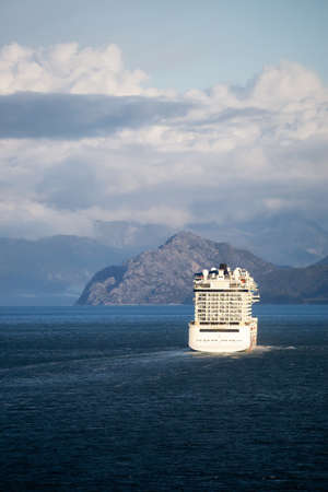Glacier Bay National Park and Preserve, Alaska, USA. Big White Cruise Ship is cuising in the Ocean during a cloudy and sunny morning in fall season.の写真素材
