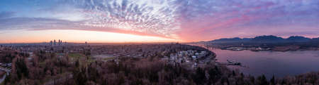 Aerial Panoramic View of a modern city during a colorful and cloudy sunset. Taken in Burnaby, Greater Vancouver, British Columbia, Canada.の写真素材