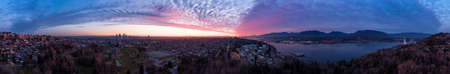 Aerial Panoramic View of a modern city during a colorful and cloudy sunset. Taken in Burnaby, Greater Vancouver, British Columbia, Canada.の写真素材