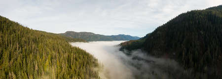 Aerial Panoramic View of Beautiful Canadian Mountain Landscape above the clouds during a sunny day....