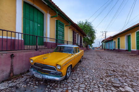 Trinidad, Cuba - June 9, 2019: View of an Old Classic American Car in the streets of a small Cuban Town during a vibrant sunny sunrise.のeditorial素材