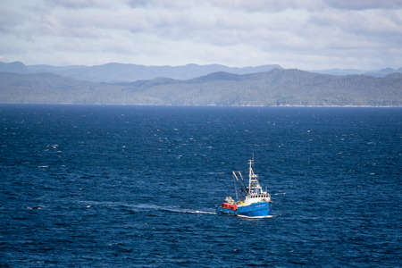 Northern Vancouver Island, British Columbia, Canada - September 27, 2019: Fishing Boat in the Pacific Ocean during a sunny and cloudy day with Islands and the Mainland in the background.のeditorial素材