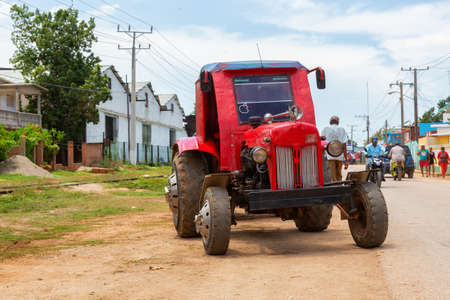 Trinidad, Cuba - June 10, 2019: Farming Tractor riding in the streets of a small Cuban Town during a vibrant sunny day.のeditorial素材