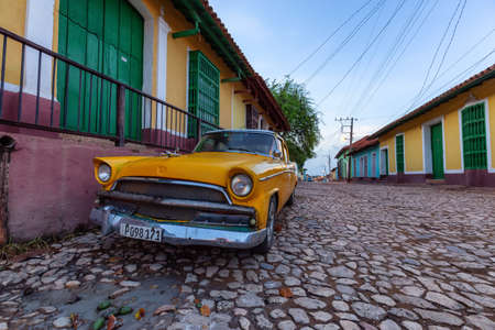Trinidad, Cuba - June 9, 2019: View of an Old Classic American Car in the streets of a small Cuban Town during a vibrant sunny sunrise.のeditorial素材