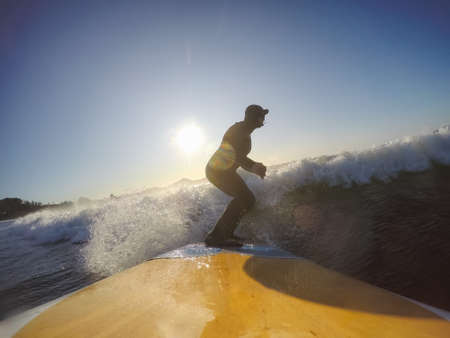 Adventurous Man Surfer on a paddle board is surfing in the ocean during a sunny morning in Fall Season. Taken in Long Beach, Tofino, Vancouver Island, BC, Canada.の写真素材