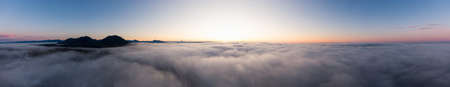 Aerial Panoramic View of Pacific Ocean Coast Covered in Fog and Clouds during a colorful sunny sunrise. Taken in Vancouver Island, BC, Canada near Tofino and Ucluelet.の写真素材