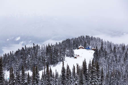 Whistler, British Columbia, Canada. Beautiful Panoramic View of the Canadian Snow Covered Mountain Landscape during a cloudy and foggy winter day.の写真素材