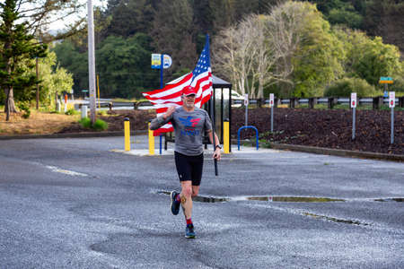 Neskowin, Oregon, United States - September 8, 2019: Proud member of Team RWB is running outside...