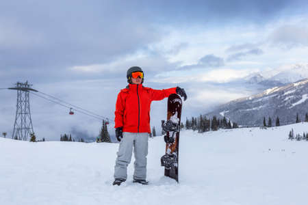 Male Snowboarder is riding down a ski run in wintertime. Taken on Whistler Mountain, British Columbia, Canada.の写真素材