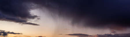 Dramatic Panoramic View of a cloudscape during a dark, rainy and colorful sunset. Taken in Alaska,...