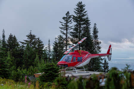 North Vancouver, British Columbia, Canada. Red Helicopter on Top of Grouse Mountain during a colorful summer sunrise.の写真素材