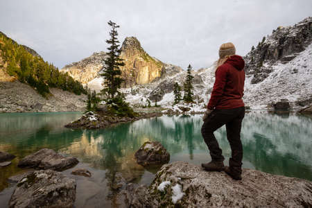 Adventurous Girl enjoying the View of a Glacier Lake in the Canadian Mountain Landscape during a...