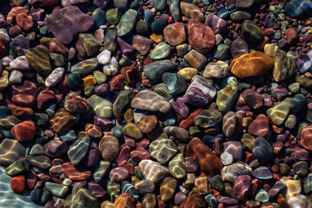 Colorful Rocks in a Glacier Lake during a sunny summer day. Taken in Lake McDonald, Glacier National Park, Montana, USA.の写真素材