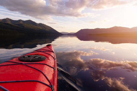 Kayaking in Lake McDonald during a sunny summer sunset with American Rocky Mountains in the background. Taken in Glacier National Park, Montana, USA.の写真素材