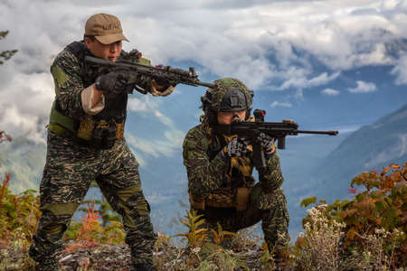 Chilliwack, British Columbia, Canada - October 5, 2019: Army Man wearing Tactical Uniform and holding Machine gun in the Outdoor Mountains during fall season.のeditorial素材