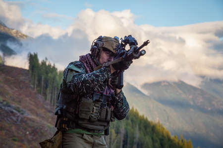 Chilliwack, British Columbia, Canada - October 5, 2019: Man in Tactical Uniform and Machine gun in the Outdoor Mountains during fall season.のeditorial素材