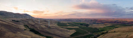 Beautiful Aerial Panoramic Landscape View of Wind Turbines on a Windy Hill during a colorful sunrise. Taken in Washington State, United States of America.の写真素材