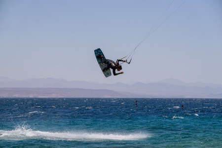 Eilat, Israel - April 12, 2019: Adventurous man is enjoying water sports, Kitesurfing, in the Red Sea during a sunny day.のeditorial素材