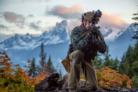 Chilliwack, British Columbia, Canada - October 5, 2019: Man in Tactical Uniform and Machine gun in the Outdoor Mountains during fall season.のeditorial素材