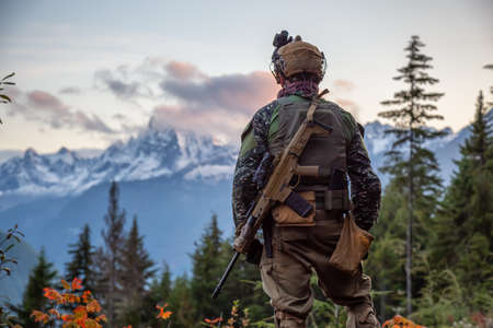 Chilliwack, British Columbia, Canada - October 5, 2019: Man in Tactical Uniform and Machine gun in the Outdoor Mountains during fall season.のeditorial素材