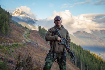 Chilliwack, British Columbia, Canada - October 5, 2019: Man in Tactical Uniform and Machine gun in the Outdoor Mountains during fall season.のeditorial素材