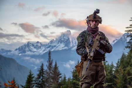 Chilliwack, British Columbia, Canada - October 5, 2019: Man in Tactical Uniform and Machine gun in the Outdoor Mountains during fall season.のeditorial素材