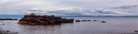 Beautiful Panoramic View of a rocky beach on the Juan de Fuca Trail during a summer sunset. Taken at...
