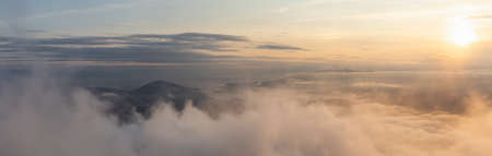 Beautiful Panoramic View of Canadian Mountain Landscape covered in clouds during a vibrant summer sunset. Taken on top of St Marks Summit, West Vancouver, British Columbia, Canada.の写真素材