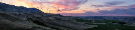 Beautiful Panoramic Landscape View of Wind Turbines on a Windy Hill during a colorful sunrise. Taken in Washington State, United States of America.の写真素材