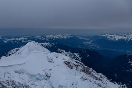 Beautiful Aerial View of Canadian Mountains Landscape during a dark and cloudy evening. Taken near...