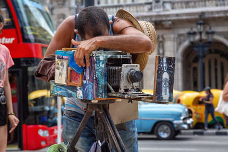 Havana, Cuba - May 29, 2019: Cuban photographer is using a Vintage Camera to take pictures in the...