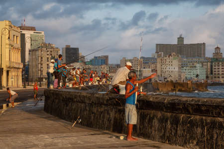 Havana, Cuba - May 25, 2019: Cuban people are fishing in the ocean early morning during a sunny and cloudy sunrise, taken during the Shortage of Food Crisis.のeditorial素材