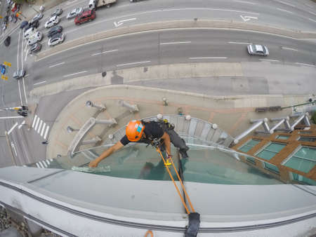 Burnaby, Vancouver, British Columbia, Canada - July 2, 2018: High rise rope access window cleaner is...
