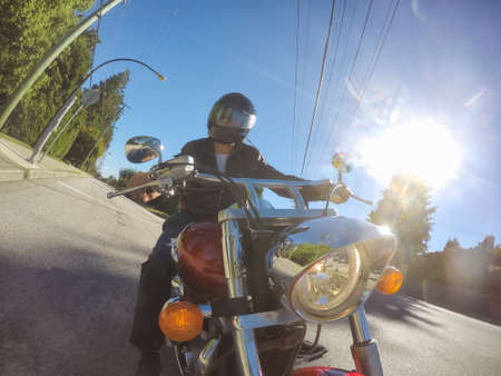 Vancouver, British Columbia, Canada - July 08, 2018: Man on a motorcycle is riding in a modern city...