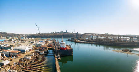Aerial panoramic view of an Industrial Site and Second Narrows Bridge during a sunny summer day....