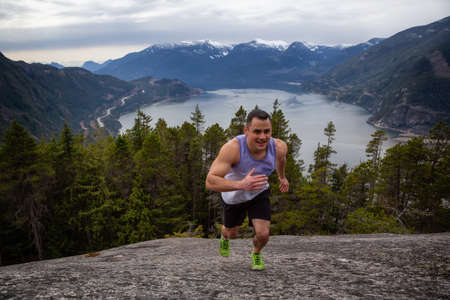Fit and Muscular Young Man is Running up the Mountain during a cloudy day. Taken on Chief Mountain...