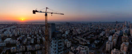 Netanya, Center District, Israel - April 2, 2019: Aerial panoramic view of a construction site in a city during a colorful sunrise.のeditorial素材