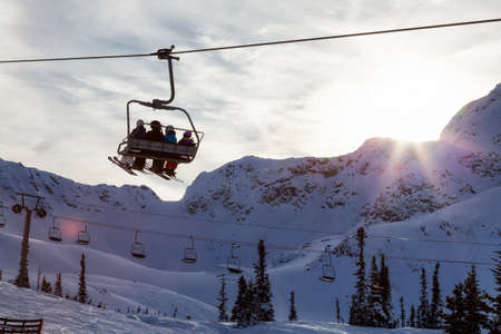 Whistler, British Columbia, Canada. People going up the mountain on a Chairlift during a vibrant and sunny winter day.の写真素材