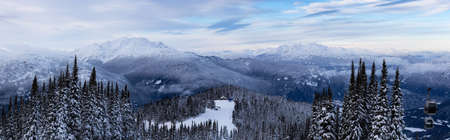 Whistler, British Columbia, Canada. Beautiful Panoramic View of the Canadian Snow Covered Mountain Landscape during a cloudy and colorful winter sunset.の写真素材