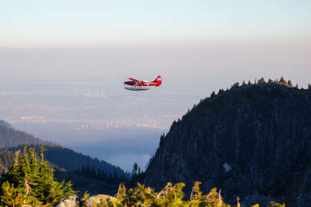 Vancouver, BC, Canada - September 6, 2018: Airplane flying around the mountains during a vibrant...