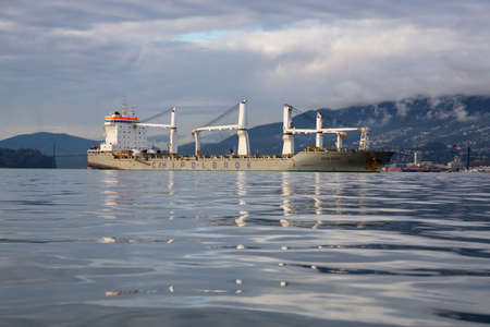 Vancouver, BC, Canada - December 24, 2018: Big cargo ship at the port during a vibrant winter sunset.のeditorial素材