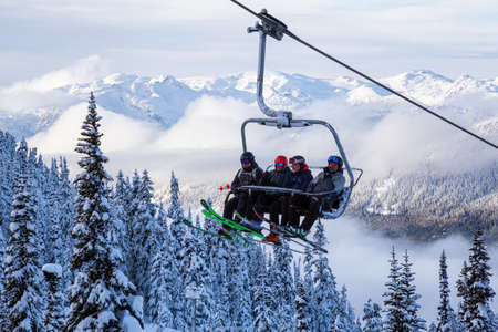 Whistler, British Columbia, Canada - January 9, 2020: People going up the mountain on a Chairlift during a vibrant and sunny winter day.のeditorial素材