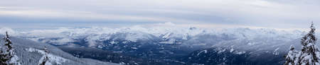 Whistler, British Columbia, Canada. Beautiful Panoramic View of the Canadian Snow Covered Mountain Landscape during a cloudy and foggy winter evening.の写真素材