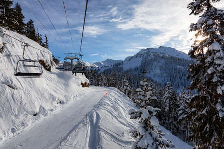 Whistler, British Columbia, Canada. Chairlift going up the mountain during a vibrant and sunny winter day.の写真素材