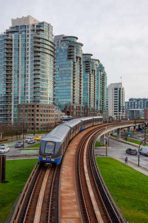 Downtown Vancouver, British Columbia, Canada - November 29, 2018: Skytrain passing in the modern city during a cloudy evening.のeditorial素材