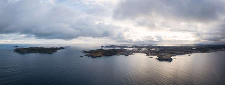 Aerial view of a small town on a rocky Atlantic Ocean Coast during a cloudy day. Taken in Paradise,...