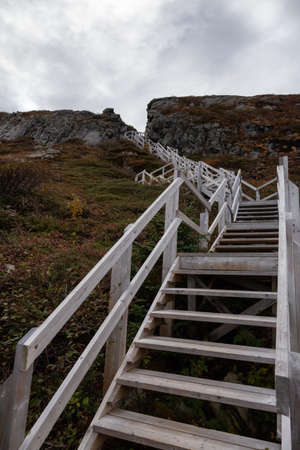 Wooden stairs going up a rocky cliff on the Atlantic Ocean Coast during a cloudy day. Taken at Dare...