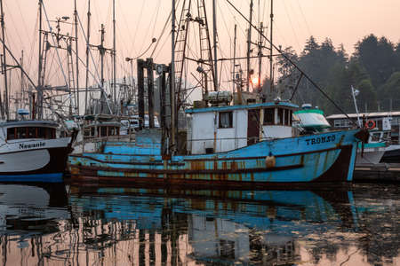 Ucluelet, Vancouver Island, BC, Canada - August 21, 2018: Fishing boats at a marina during a smoky...