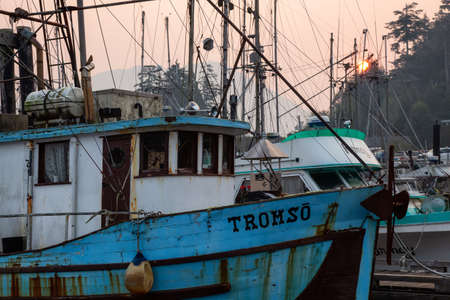 Ucluelet, Vancouver Island, BC, Canada - August 21, 2018: Fishing boats at a marina during a smoky...