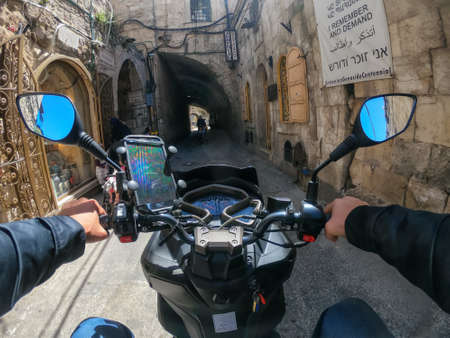 Jerusalem, Israel - April 16, 2019: Riding a scooter in the busy urban streets during a cloudy and...